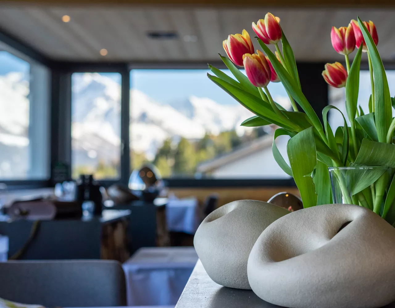Salle du restaurant avec tulipes et vue sur les montagnes